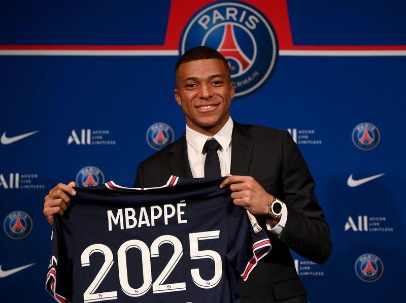 Paris Saint-Germain's French forward Kylian Mbappe poses with a jersey at the end of a press conference at the Parc des Princes stadium in Paris on May 23, 2022, two days after the club won the Ligue 1 title for a record-equalling tenth time and its superstar striker Mbappe chose to sign a new contract until 2025 at PSG rather than join Real Madrid. (Photo by FRANCK FIFE / AFP) (Photo by FRANCK FIFE/AFP via Getty Images)
