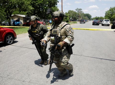 Law enforcement personnel run away from the scene of a suspected shooting near Robb Elementary School in Uvalde, Texas, U.S. May 24, 2022.  REUTERS/Marco Bello