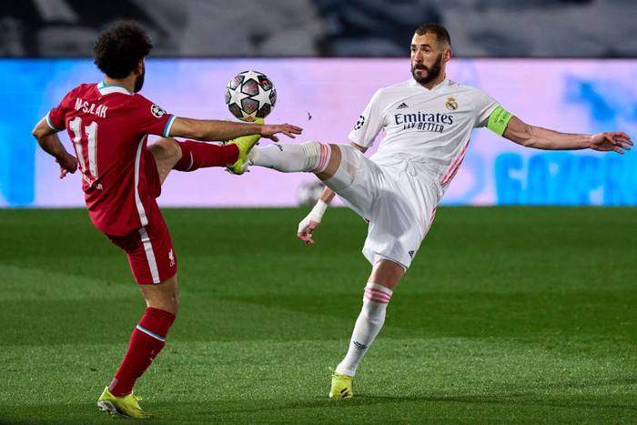 MADRID, SPAIN - APRIL 06: Karim Benzema of Real Madrid battle for the ball with Mohamed Salah of Liverpool FC during the UEFA Champions League Quarter Final match between Real Madrid and Liverpool FC at Estadio Alfredo Di Stefano on April 06, 2021 in Madrid, Spain. (Photo by Diego Souto/Quality Sport Images/Getty Images)
