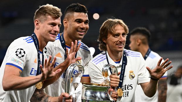 Madrid Juara Liga Champions (From L) Real Madrid's German midfielder Toni Kroos, Real Madrid's Brazilian midfielder Casemiro and Real Madrid's Croatian midfielder Luka Modric pose with the trophy after winning the UEFA Champions League final football match between Liverpool and Real Madrid at the Stade de France in Saint-Denis, north of Paris, on May 28, 2022. (Photo by Anne-Christine POUJOULAT / AFP)