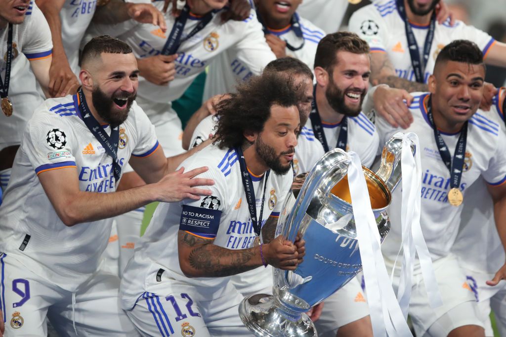 PARIS, FRANCE - MAY 28: Marcelo and Karim Benzema of Real Madrid celebrate with the trophy among team mates during the UEFA Champions League final match between Liverpool FC and Real Madrid at Stade de France on May 28, 2022 in Paris, France. (Photo by Marc Atkins/Getty Images)