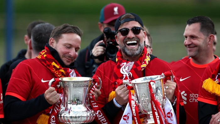 Juergen Klopp LIVERPOOL, ENGLAND - MAY 29: Pep Lijnders, Assistant Manager and Jurgen Klopp, Manager of Liverpool pose with the FA Cup and the Carabao Cup Trophy during the Liverpool Trophy Parade on May 29, 2022 in Liverpool, England. (Photo by Jan Kruger/Getty Images)