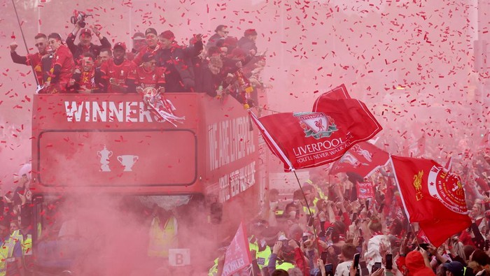 Parade akhir musim Liverpool berlangsung meriah meski The Reds gagal juara Liga Champions. Kehadiran para suporter kian memeriahkan parade itu. Ini fotonya.