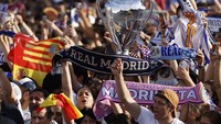 Tak hanya membawa berbagai atribut bertema Real Madrid, ada pula pendukung yang membawa serta balon berbentuk trofi Liga Champions saat berpesta merayakan kemenangan El Real. REUTERS/Marcelo Del Pozo.