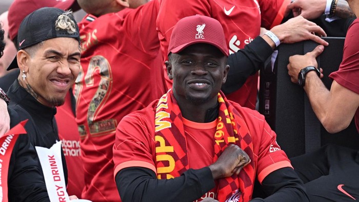Liverpools Brazilian striker Roberto Firmino (L) and Liverpools Senegalese striker Sadio Mane celebrate from an open-top bus during a parade through the streets of Liverpool in north-west England on May 29, 2022, after winning the 2021-22 League Cup and FA Cup. - Despite the disappointment of losing to real Madrid in the final of the UEFA Champions League, Klopp has called on Liverpool fans to take to the streets of the city on Sunday when they parade the League Cup and FA Cup. (Photo by Oli SCARFF / AFP) (Photo by OLI SCARFF/AFP via Getty Images)