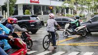 Ada-ada Saja, Pesepeda Ini Gowes Pakai Helm Motor