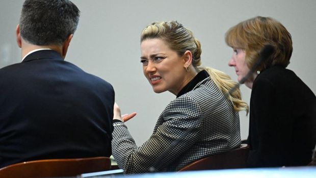 Actor Amber Heard reacts as a pre-recorded deposition testimony of Christian Carino is played during her ex-husband Johnny Depp's defamation trial against her, at the Fairfax County Circuit Courthouse in Fairfax, Virginia, April 27, 2022. - US actor Johnny Depp sued his ex-wife Amber Heard for libel in Fairfax County Circuit Court after she wrote an op-ed piece in The Washington Post in 2018 referring to herself as a 