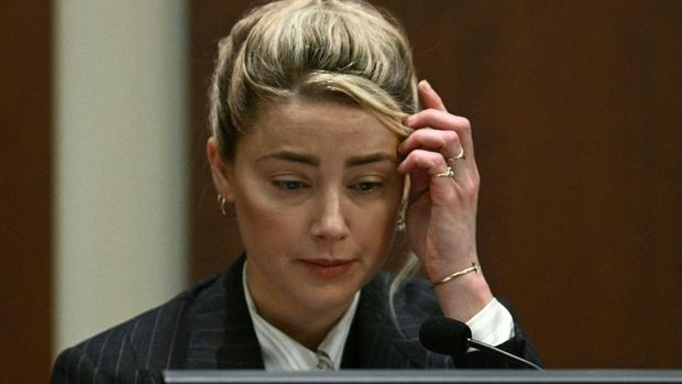 Actor Amber Heard reacts as a pre-recorded deposition testimony of Christian Carino is played during her ex-husband Johnny Depp's defamation trial against her, at the Fairfax County Circuit Courthouse in Fairfax, Virginia, April 27, 2022. - US actor Johnny Depp sued his ex-wife Amber Heard for libel in Fairfax County Circuit Court after she wrote an op-ed piece in The Washington Post in 2018 referring to herself as a 