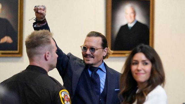 TOPSHOT - Actor Johnny Depp gestures to spectators in court after closing arguments at the Fairfax County Circuit Courthouse in Fairfax, Virginia, on May 27, 2022. - Actor Johnny Depp is suing ex-wife Amber Heard for libel after she wrote an op-ed piece in The Washington Post in 2018 referring to herself as a public figure representing domestic abuse. (Photo by Steve Helber / POOL / AFP) (Photo by STEVE HELBER/POOL/AFP via Getty Images)