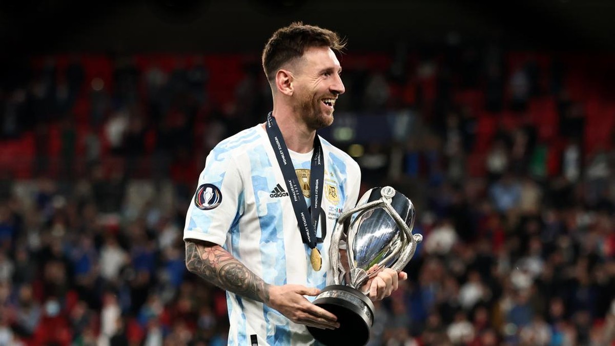 Lionel Messi memegang trofi juara Finalissima usai Argentina menekuk Italia 3-0. (Foto: Marc Atkins/Getty Images)
