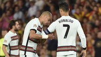 Pepe menyerahkan ban kapten kepada Ronaldo di lapangan. (Foto: AFP via Getty Images/CRISTINA QUICLER)