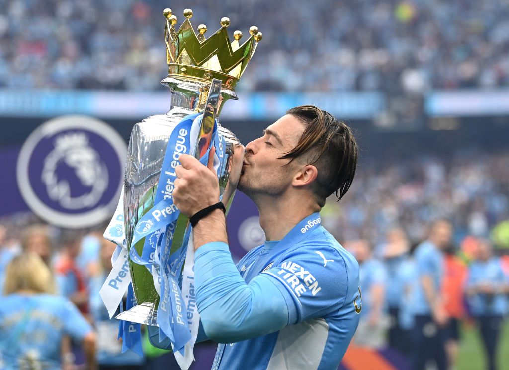 MANCHESTER, ENGLAND - MAY 22:  Jack Grealish of Manchester City celebrates with the Premier League trophy after their side finished the season as Premier League champions after the Premier League match between Manchester City and Aston Villa at Etihad Stadium on May 22, 2022 in Manchester, England. (Photo by Shaun Botterill/Getty Images)