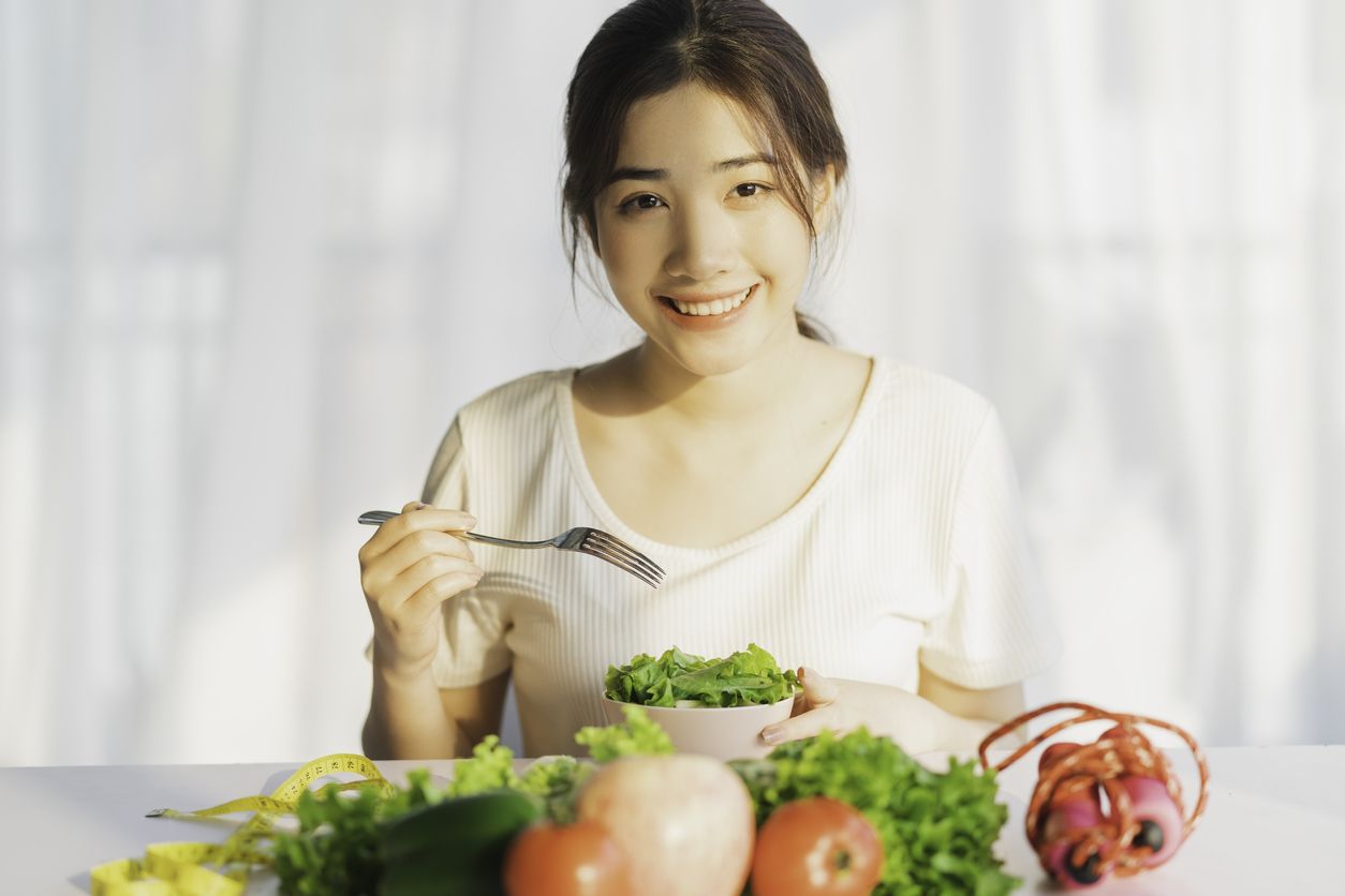 Young woman is eating green vegetables for weight loss