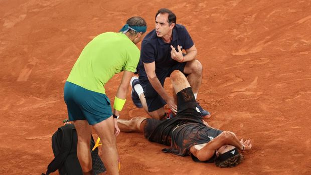 PARIS, FRANCE - JUNE 03: Rafael Nadal of Spain checks on Alexander Zverev (aka Sascha Zverev) of Germany as he receives medical attention following an injury against Rafael Nadal of Spain during the Men's Singles Semi Final match on Day 13 of The 2022 French Open at Roland Garros on June 03, 2022 in Paris, France. (Photo by John Berry/Getty Images)