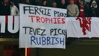 Sebaliknya, fans MU geram sekali dengan kepindahan Carlos Tevez yang dianggap mata duitan. Cibiran pun rutin mereka suarakan ke arah Tevez. Foto: Corbis via Getty Images/Matthew Ashton