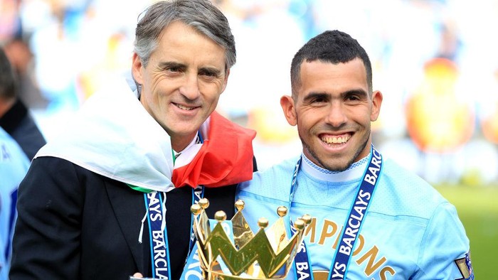 Manchester City manager Roberto Mancini, draped in an Italian Flag, and Carlos Tevez, celebrate with the Barclays Premier League Trophy   (Photo by Mike Egerton - PA Images via Getty Images)