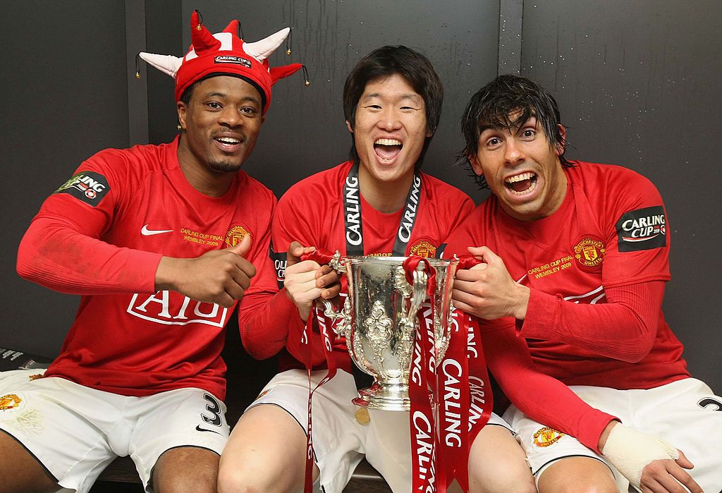 LONDON, ENGLAND - MARCH 1:  (MINIMUM USAGE FEE APPLIES - 250 GBP OR LOCAL EQUIVALENT) Patrice Evra, Ji-Sung Park and Carlos Tevez of Manchester United pose in the dressing room with the Carling Cup trophy after the Carling Cup Final match between Manchester United and Tottenham Hotspur at Wembley Stadium on March 1 2009 in London, England. (Photo by John Peters/Manchester United via Getty Images)