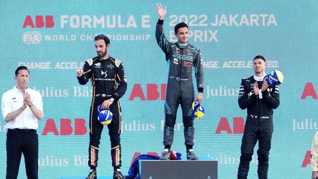 Jaguar TCS driver Mitch Evans of New Zealand waves on the podium after winning Jakarta E-Prix Formula E auto race as Jaguar TCS Team Principal James Barclay, left, second place winner DS Techeetah's Jean-Eric Vergne of France and third place Rokit Venturi's Edoardo Mortara of Switzerland applaud, in Jakarta, Indonesia, Saturday, June 4, 2022. (AP Photo/Achmad Ibrahim)