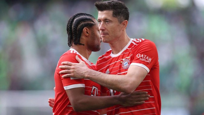 Bayern Munichs Polish forward Robert Lewandowski (R) hugs Bayern Munichs German midfielder Serge Gnabry after the German first division Bundesliga football match VfL Wolfsburg v Bayern Munich in Wolfsburg, northern Germany, on May 14, 2022. - DFL REGULATIONS PROHIBIT ANY USE OF PHOTOGRAPHS AS IMAGE SEQUENCES AND/OR QUASI-VIDEO (Photo by Ronny Hartmann / AFP) / DFL REGULATIONS PROHIBIT ANY USE OF PHOTOGRAPHS AS IMAGE SEQUENCES AND/OR QUASI-VIDEO (Photo by RONNY HARTMANN/AFP via Getty Images)
