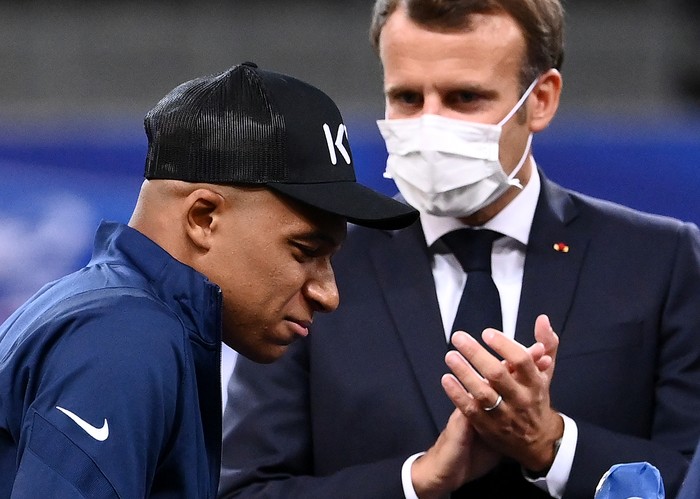 French President Emmanuel Macron (R) applauds as Paris Saint-Germains French forward Kylian Mbappe walks with crutches onto a platform for the trophy ceremony after winning the French Cup final football match between Paris Saint-Germain (PSG) and Saint-Etienne (ASSE), at The Stade de France in Saint-Denis, outside Paris on July 24, 2020. - Paris Saint-Germain coach Thomas Tuchel said 