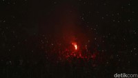 Nampak flare berwarna merah menyala dari tribun, asap dari flare pun mengebul di dalam stadion.