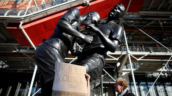 Zinedine Zidane, Marco Materazzi A man holds a banner denouncing violence on September 30, 2012, in Paris in front of a bronze sculpture by French Algerian born artist Adel Abdessemed displayed in front of the Centre Pompidou contemporary art center, aka Beaubourg. The sculpture immortalizes the