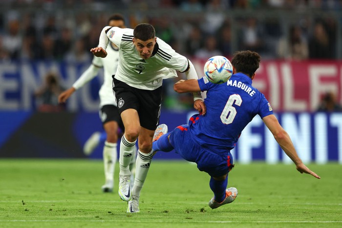 MUNICH, GERMANY - JUNE 07: Kai Havertz of Germany is challenged by Harry Maguire of England during the UEFA Nations League League A Group 3 match between Germany and England at Allianz Arena on June 07, 2022 in Munich, Germany. The German national team will play the match in the Women’s national kit in support of their upcoming UEFA Women’s European Championship campaign. (Photo by Alexander Hassenstein/Getty Images)
