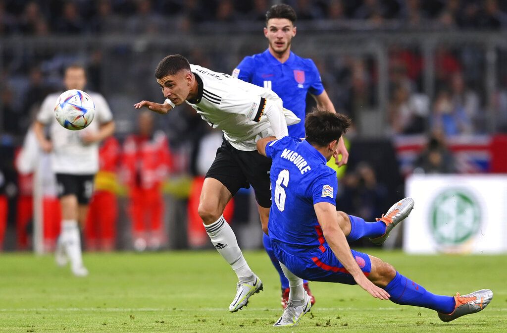 Germany's Kai Havertz, left, challenges for the ball with England's Harry Maguire during the UEFA Nations League soccer match between Germany and England at the Allianz Arena, in Munich, Germany, Tuesday, June 7, 2022. (AP Photo/Markus Ulmer)