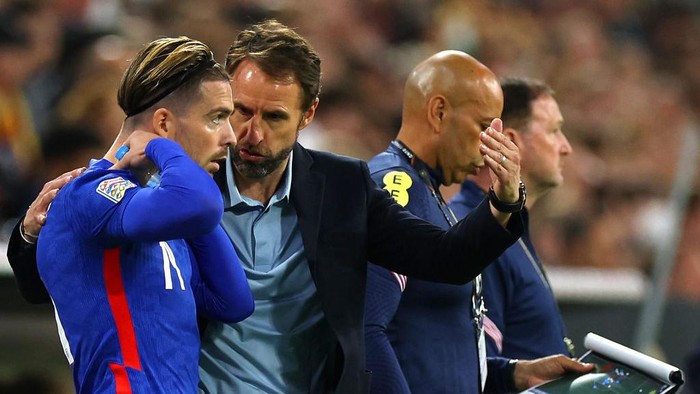 MUNICH, GERMANY - JUNE 07: Gareth Southgate speaks to Jack Grealish of England before they are substituted on during the UEFA Nations League League A Group 3 match between Germany and England at Allianz Arena on June 07, 2022 in Munich, Germany. (Photo by Eddie Keogh - The FA/The FA via Getty Images)