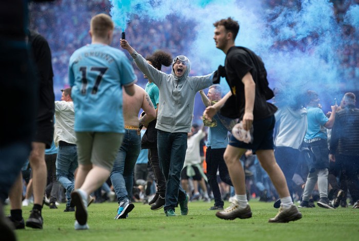 MANCHESTER, ENGLAND - MAY 22: Manchester City fans celebrate winning the Premier League title on the pitch by  climbing onto the roof of the net as the crossbar snaps after the Premier League match between Manchester City and Aston Villa at Etihad Stadium on May 22, 2022 in Manchester, England. (Photo by Stu Forster/Getty Images)