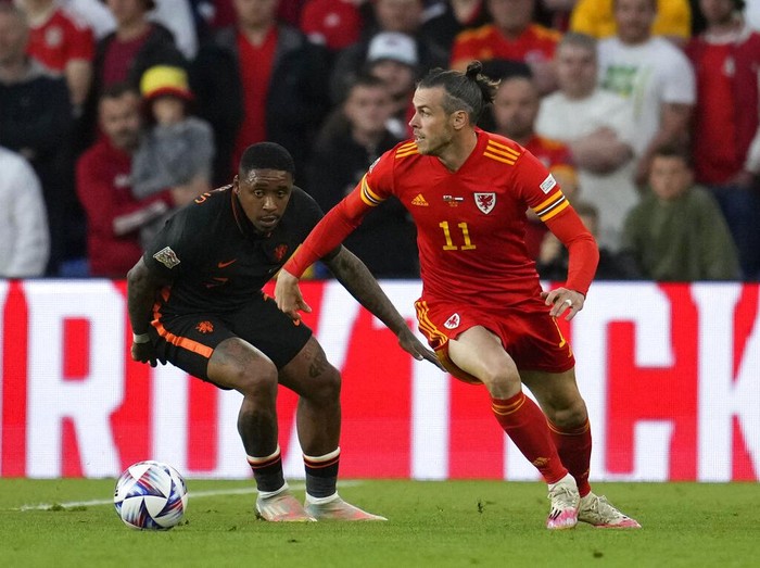 Kemenangan Dramatis Belanda Atas Wales Wales's Rhys Norrington-Davies, front, duels for the ball with Netherlands' Hans Hateboer during the UEFA Nations League soccer match between Wales and the Netherlands at Cardiff City Stadium, in Cardiff, Wales, Wednesday, June 8, 2022. (AP Photo/Matt Dunham )
