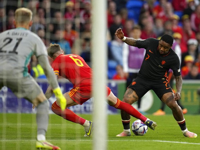 Wales's Rhys Norrington-Davies, front, duels for the ball with Netherlands' Hans Hateboer during the UEFA Nations League soccer match between Wales and the Netherlands at Cardiff City Stadium, in Cardiff, Wales, Wednesday, June 8, 2022. (AP Photo/Matt Dunham )