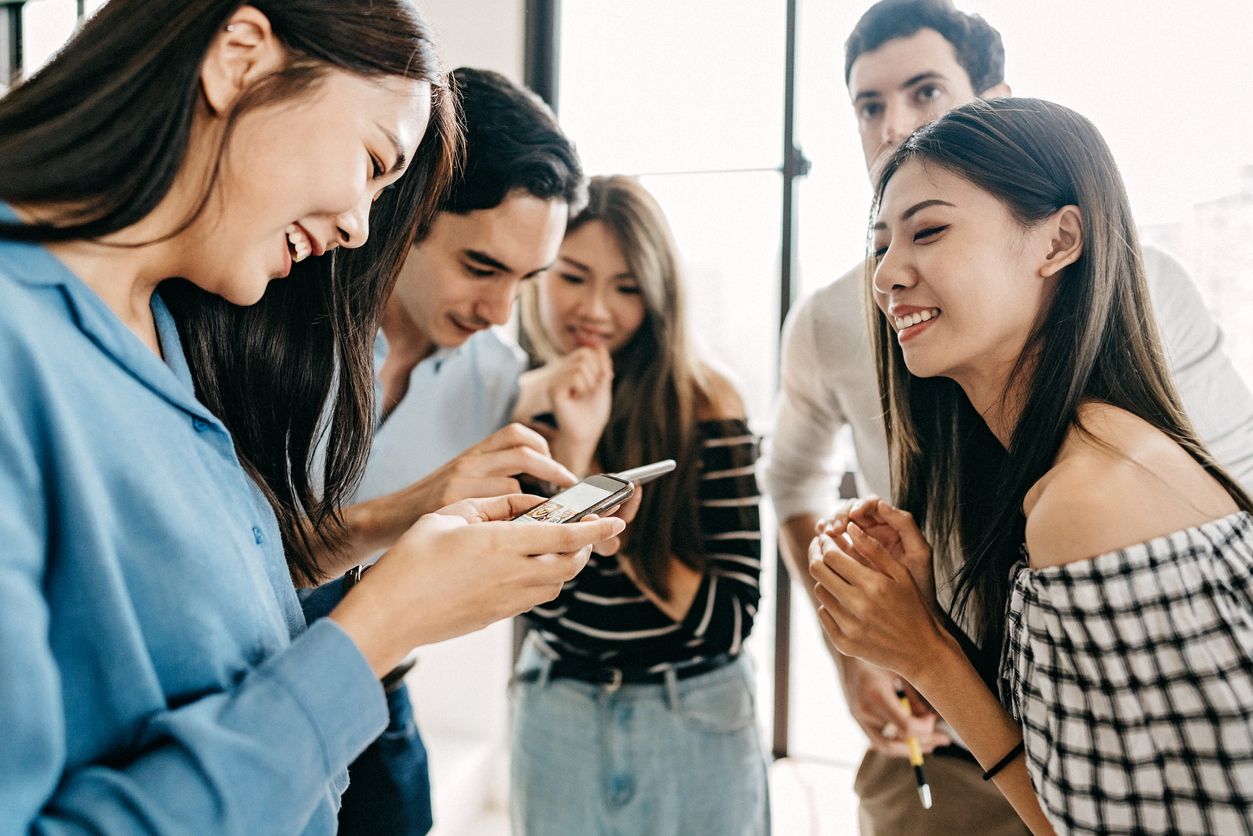 Group of Students Using Devices To Surf The Net While Having Fun In Comfortable Room