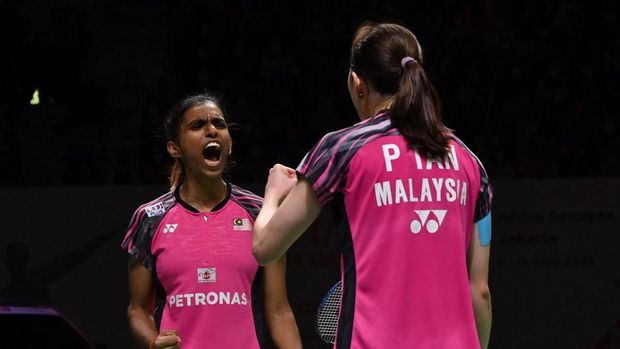 Thinaah Muralitharan (L) and Pearly Tan (R) of Malaysia react as they play against Apriyani Rahayu and Siti Fadia Silva Ramadhanti of Indonesia during their womens doubles semifinal at the Indonesia Masters badminton tournament in Jakarta on June 11, 2022. (Photo by ADEK BERRY / AFP)