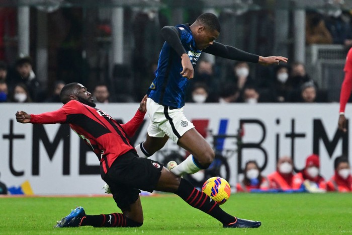 AC Milan's English defender Fikayo Tomori (L) tackles Inter Milan's Dutch defender Denzel Dumfries during the Italian Cup (Coppa Italia) semi-final first leg football match AC Milan vs Inter Milan at the Giuseppe Meazza Stadium (also called San Siro), in Milan on March 1, 2022. (Photo by MIGUEL MEDINA / AFP) (Photo by MIGUEL MEDINA/AFP via Getty Images)