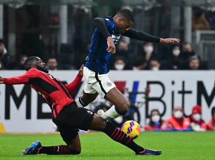 AC Milan's English defender Fikayo Tomori (L) tackles Inter Milan's Dutch defender Denzel Dumfries during the Italian Cup (Coppa Italia) semi-final first leg football match AC Milan vs Inter Milan at the Giuseppe Meazza Stadium (also called San Siro), in Milan on March 1, 2022. (Photo by MIGUEL MEDINA / AFP) (Photo by MIGUEL MEDINA/AFP via Getty Images)