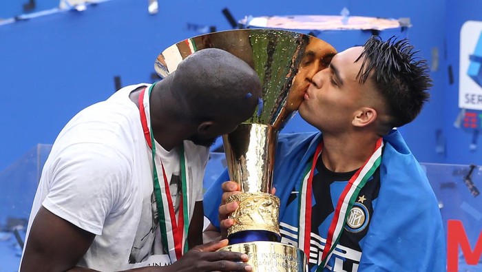 MILAN, ITALY - MAY 23: Romelu Lukaku and Lautaro Martinez of Internazionale kiss the Scudetto trophy following the Serie A match between FC Internazionale Milano and Udinese Calcio at Stadio Giuseppe Meazza on May 23, 2021 in Milan, Italy. Sporting stadiums around Italy remain under strict restrictions due to the Coronavirus Pandemic as Government social distancing laws prohibit fans inside venues resulting in games being played behind closed doors (Photo by Jonathan Moscrop/Getty Images)