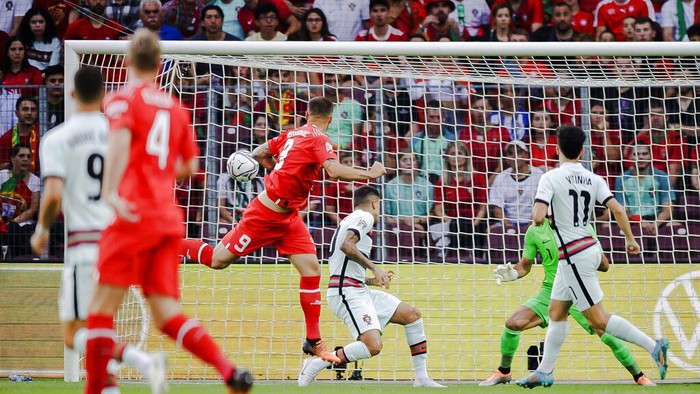 Portugal's midfielder Bruno Fernandes, center, fights for the ball with Switzerland's defender Ricardo Rodriguez, left, and Switzerland's defender Nico Elvedi, right, during the UEFA Nations League group A2 soccer match between Switzerland and Portugal at the Stade de Geneve stadium, in Geneva, Switzerland, Sunday, June 12, 2022. (Jean-Christophe Bott/Keystone via AP)