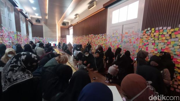 Warga menempelken kertas berisi doa di Gedung Pakuan.