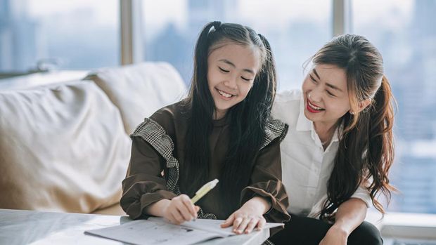 asian chinese young family mother daughter enjoying bonding time doing homework  at home during weekend in living room apartment