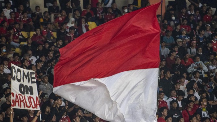 Suporter Timnas Indonesia mengibarkan bendera Merah Putih saat laga persahabatan FIFA di Stadion Si Jalak Harupat, Kabupaten Bandung, Jawa Barat, Rabu (1/6/2022). Pertandingan Indonesia melawan Bangladesh berakhir dengan skor 0-0. ANTARA FOTO/M Agung Rajasa/nz