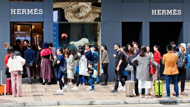 Tsim Sha Tsui, Hong Kong - 08 December, 2018 : People walk past the HERMES Shop in Canton Road, Hong Kong. People queuing outside and waiting to enter the store.