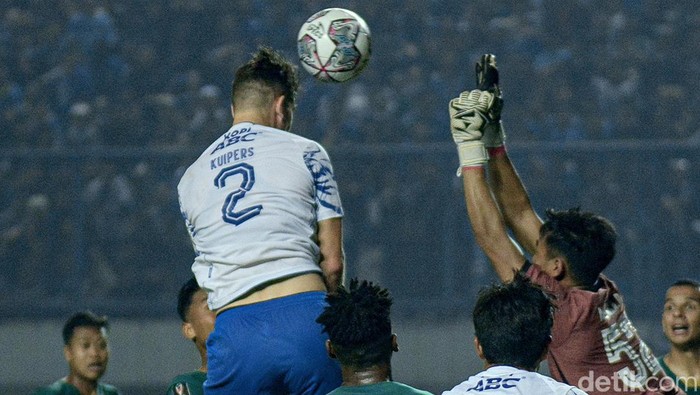 Bek Nick Kuipers menyundul bola yang menghasilkan gol pembalik keadaan bagi Persib saat bersua Persebaya