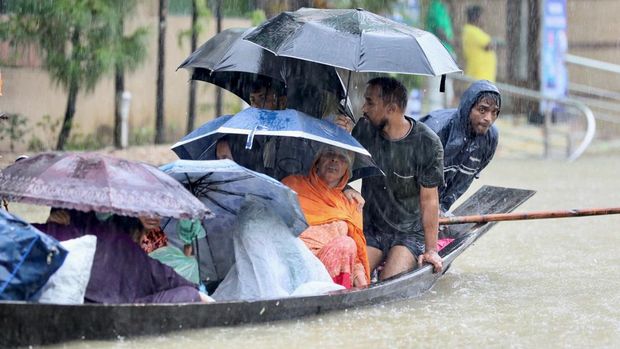 People get on a boat as they look for shelter during a flood, amidst heavy rains that caused widespread flooding in the northeastern part of the country, in Sylhet, Bangladesh, June 18, 2022. REUTERS/Abdul Goni NO RESALES. NO ARCHIVES
