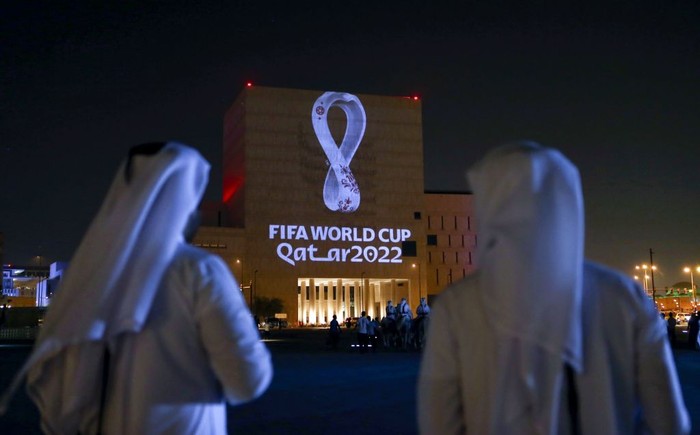 TOPSHOT - Qataris gather at the capital Dohas traditional Souq Waqif market as the official logo of the FIFA World Cup Qatar 2022 is projected on the front of a building on September 3, 2019. (Photo by - / AFP)        (Photo credit should read -/AFP via Getty Images)