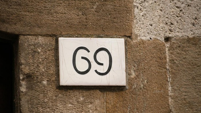 posisi 69 House number on brick old wall. Sexy 69 license plate on the wall of ancient building. Yin yang concept.
