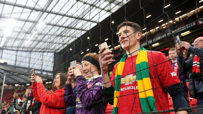 MANCHESTER, ENGLAND - MAY 02: Fans of Manchester United take pictures on their phones ahead of the Premier League match between Manchester United and Brentford at Old Trafford on May 02, 2022 in Manchester, England. (Photo by Catherine Ivill/Getty Images)
