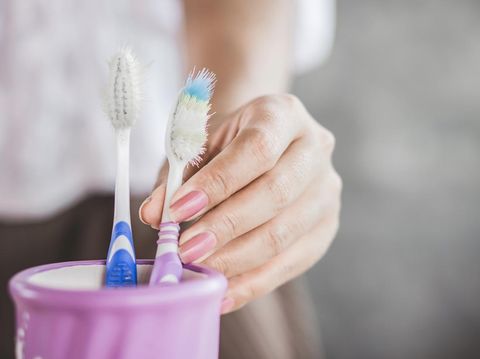 woman hand using old and destroy toothbrush closeup