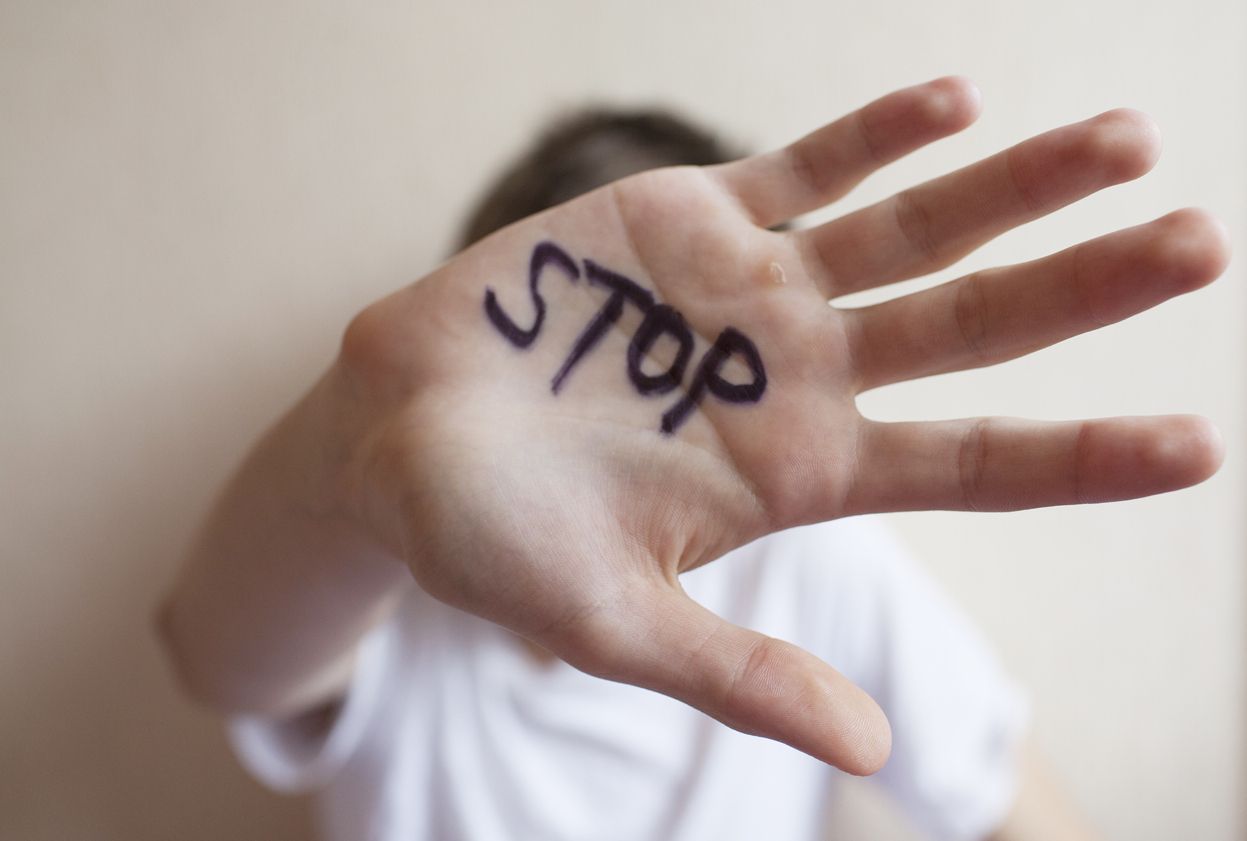 Teen boy protects himself with his hand in the palm of his inscription 