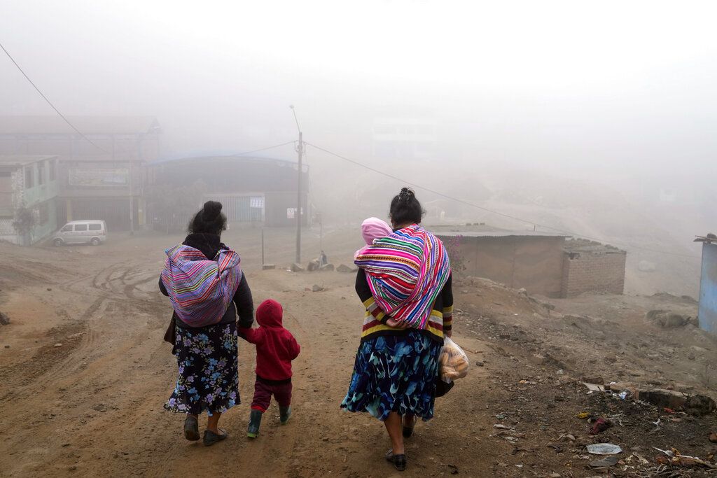 A resident walks through cold and heavy fog in the Ticlio Chico neighborhood on the outskirts of Lima, Peru, on the first official day of winter, Tuesday, June 21, 2022. Temperatures in the capital are the lowest in 25 years, according to the National Service of Meteorology and Hydrology of Peru. (AP Photo/Martin Mejia)